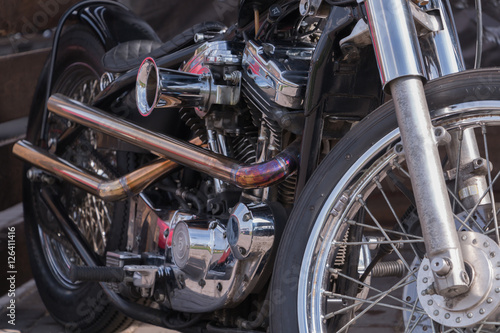 Motorcycle engine close-up. Chrome, shiny parts, wheels, exhaust.