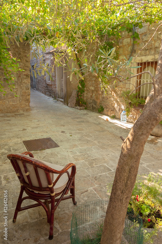 Chair under tree in patio in old town of Budva, Montenegro.
