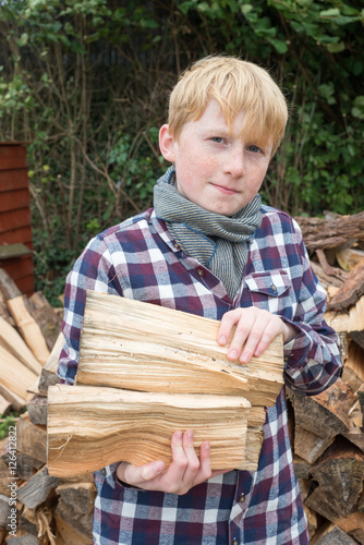 Boy in Front of Pile of Firewood