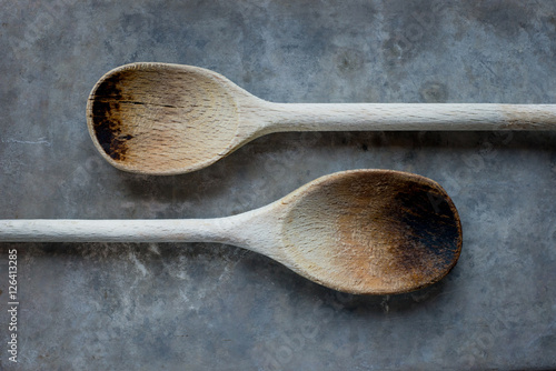Two Old Wooden Spoons on a Grey Background