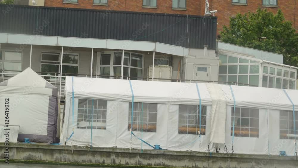 White tents floating in a river in Dublin it is like a restaruant with some chairs and tables inside the white tents White tents floating in a river in Dublin it is like a restaruant with some chairs and tables inside the white tents