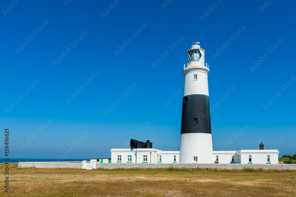 Lighthouse on Alderney, Channel Islands, UK on summer day.