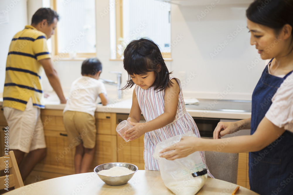 Family home. Two parents and two children preparing a meal. Family home. Two parents and two children preparing a meal.
