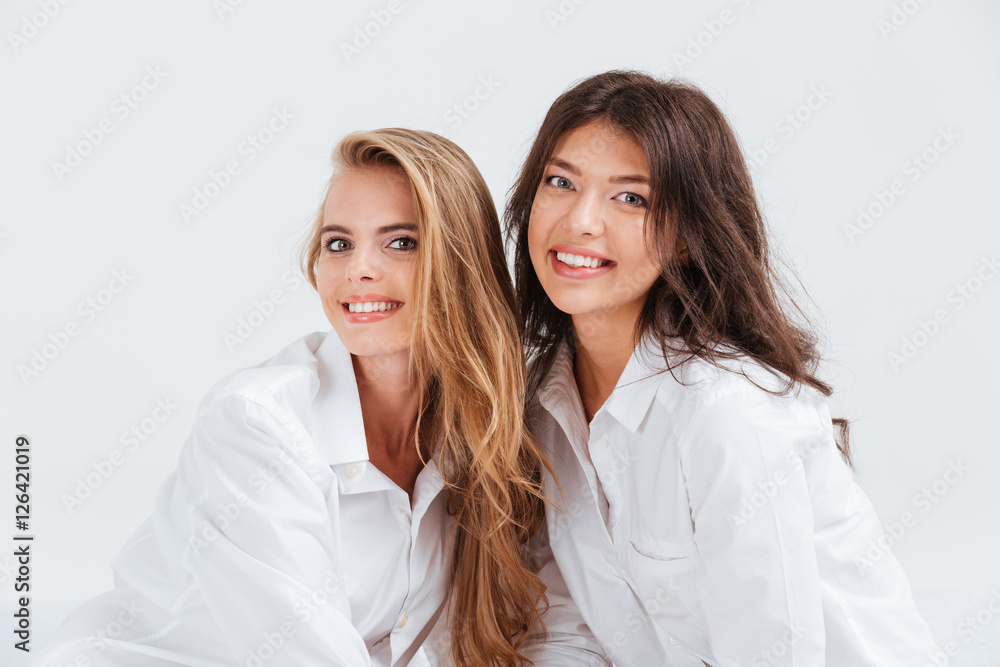 Close up portrait of two female friends wearing white shirts Close up portrait of two female friends wearing white shirts