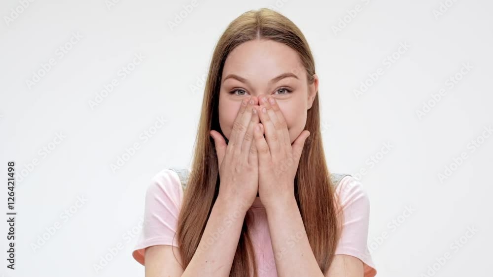 Surprised young beautiful girl laughing over white background. Slow motion. Surprised young beautiful girl laughing over white background. Slow motion.