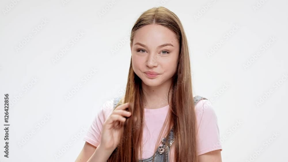 Young beautiful girl smiling over white background. Slow motion. Young beautiful girl smiling over white background. Slow motion.