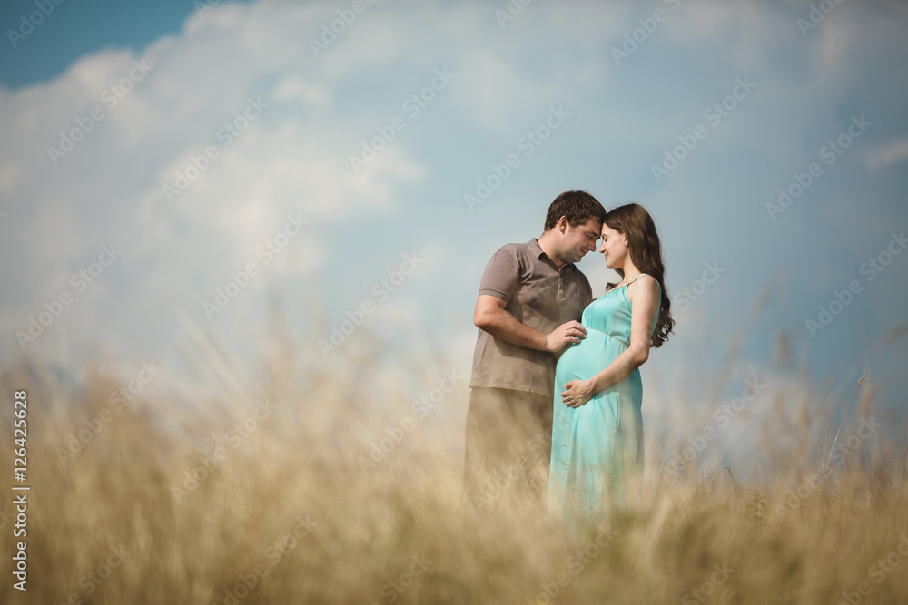 Beautiful pregnant woman with her husband posing outside Beautiful pregnant woman with her husband posing outside