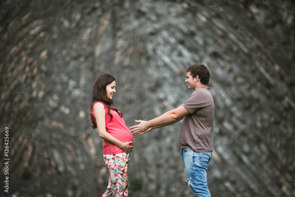Fototapeta premium Beautiful pregnant woman with her husband posing outside