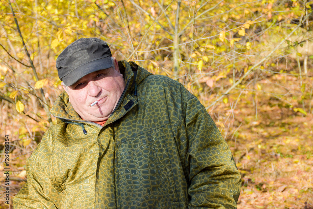 Mature caucasian man smoking cigarette outside Mature caucasian man smoking cigarette outside