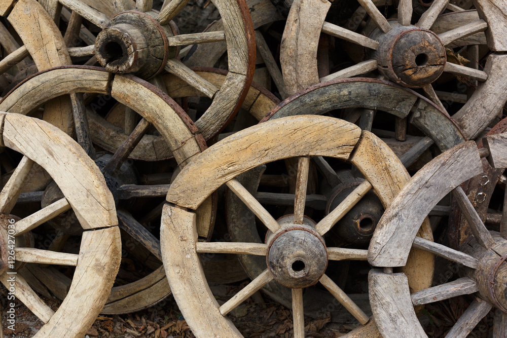 Background with a group of old and unused wooden wheels