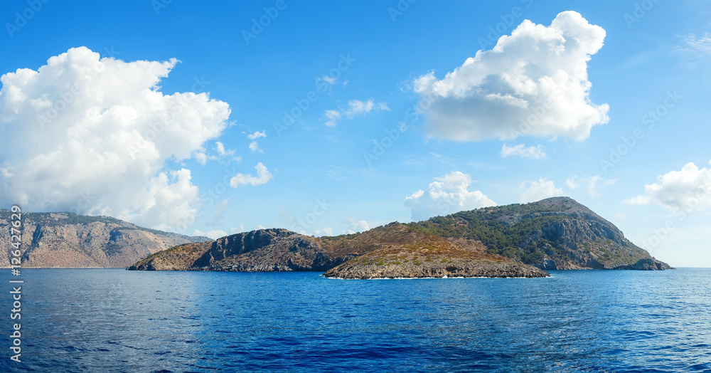 Blue sky and sea landscape with mountains white clouds in horizon