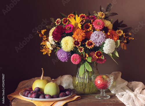 Autumn still life with bouquet and fruits.