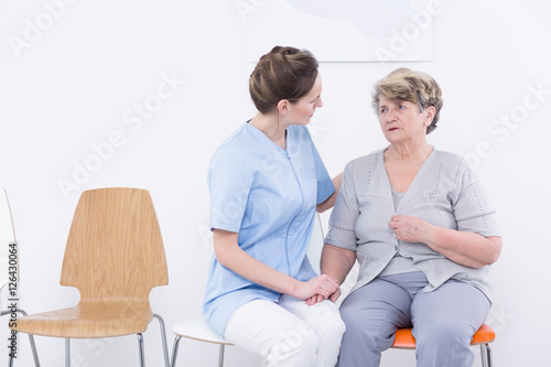  Nurse sitting close to the senior woman