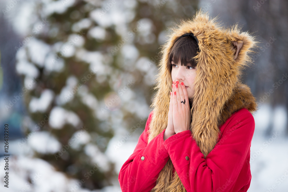 Portrait of unhappy beautiful young woman wearing red winter coat and funny  hat walking outdoors, feeling cold in wintertime, blowing on her frozen  hands trying to warm up Stock Photo | Adobe
