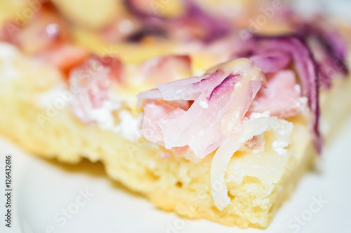 Delicious homemade sour cream pizza with ham and sliced red onions