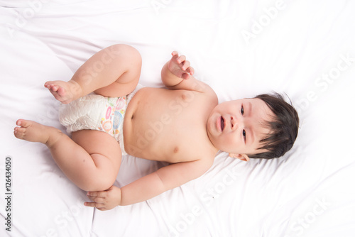 Portrait of cute Little asian boy 6 months old on the white bed