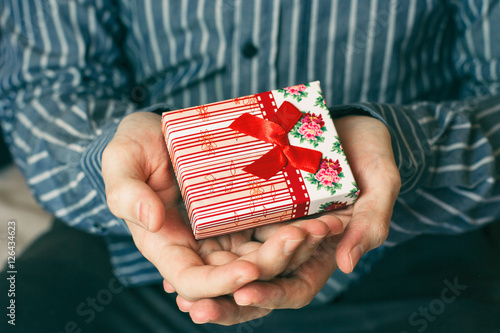 Hombre joven sujetando entre sus manos un regalo muy especial photo