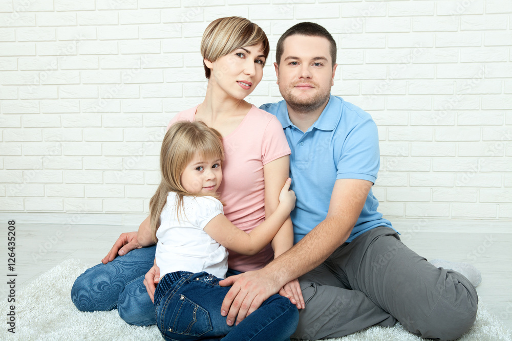 happy family mother, father and two children playing and cuddling at home on floor happy family mother, father and two children playing and cuddling at home on floor