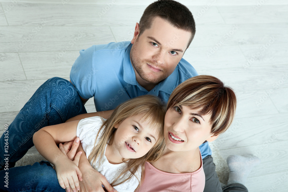happy family mother, father and two children playing and cuddling at home on floor. Unusually view from above. happy family mother, father and two children playing and cuddling at home on floor. Unusually view from above.