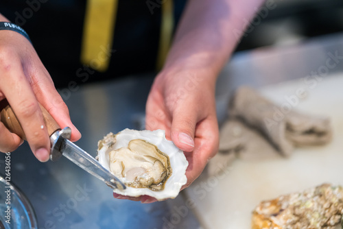 guy shucking an oyster with his bare hands

