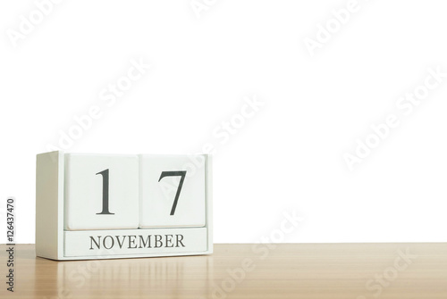 Closeup surface white wooden calendar with black 17 november word on blurred brown wood desk isolated on white background with copy space , selective focus at the calendar