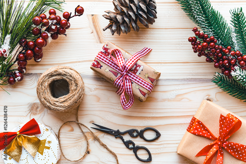 Christmas decoration with fir tree branch, pine cones, scissors and gifts on wooden background, top view, flat lay. Christmas decoration with fir tree branch, pine cones, scissors and gifts on wooden background, top view, flat lay.