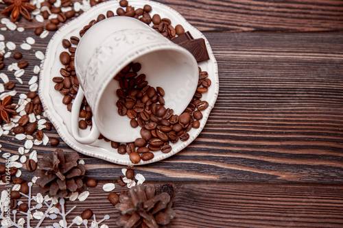 Coffee cup and beans on wooden background.