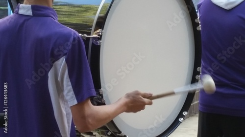 Drummer at a Parade Drumming on a Bass Drum in a Marching Band