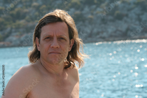 Мужчина с длинными волосами на море