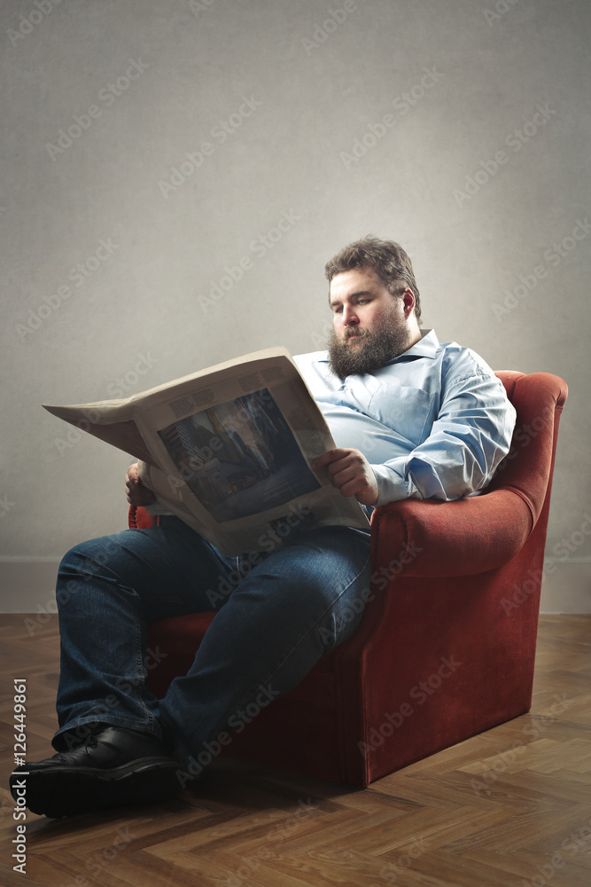 Fat man reading a newspaper