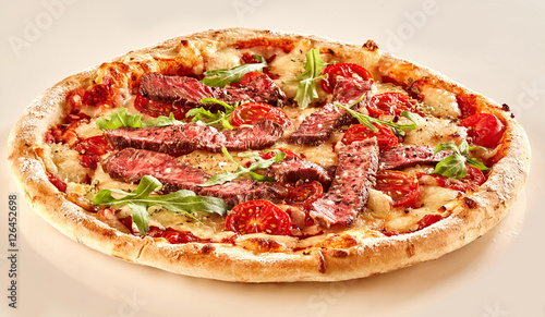 Strips of beef and fresh lettuce on pizza