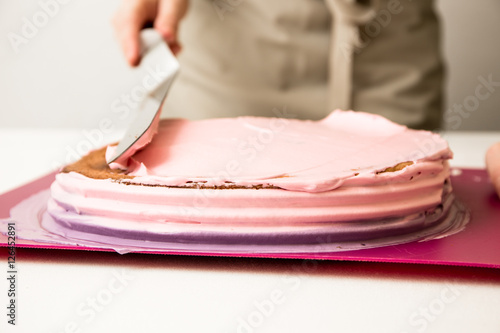 Fotografie Die Torte mit der Creme streichen