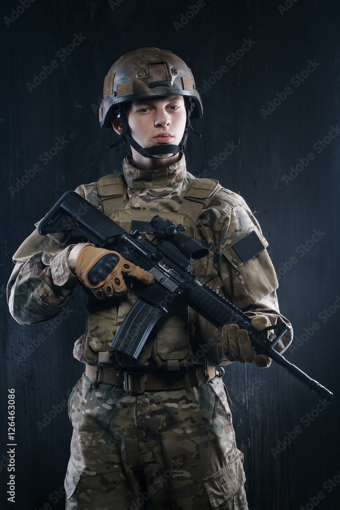 Proud soldier with his head held high holding a gun and looking confidently forward. Proud soldier with his head held high holding a gun and looking confidently forward.