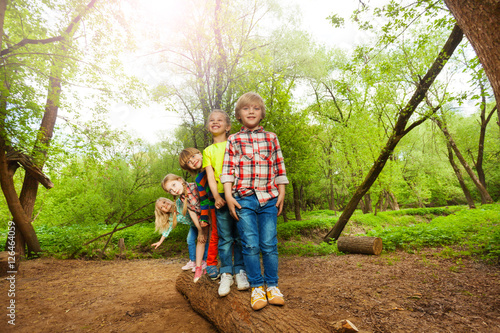 Φωτογραφία Cute kids standing on a log in the forest