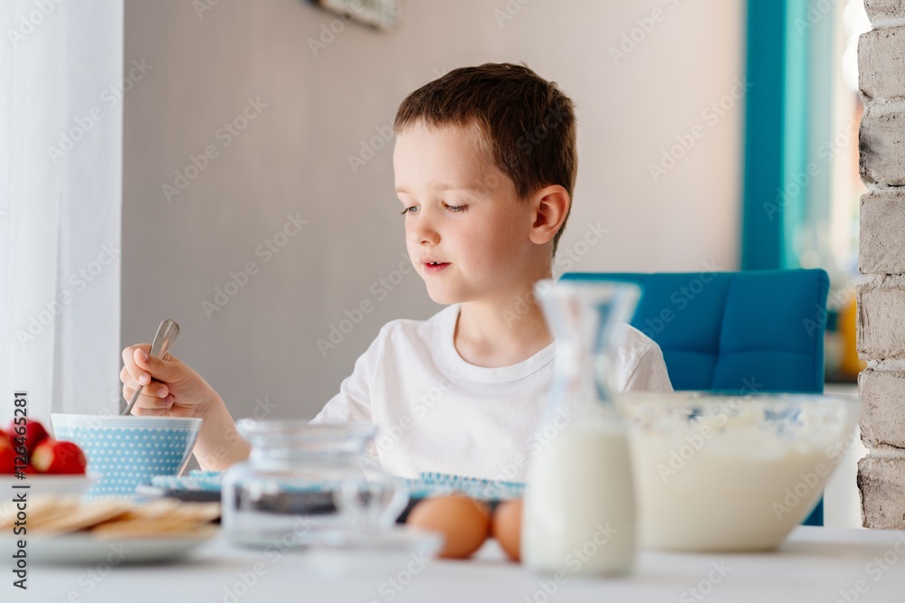 Child filling cupcakes form with dough ingredients Child filling cupcakes form with dough ingredients