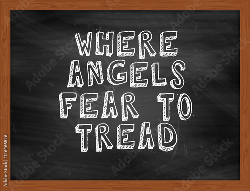 WHERE ANGELS FEAR TO TREAD handwritten text on black chalkboard