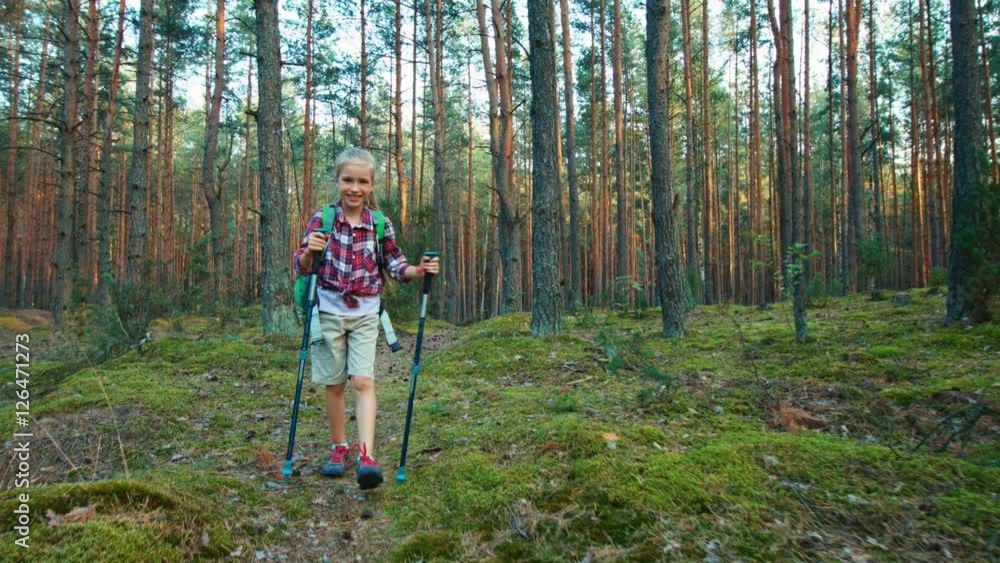 Little hiker girl child walking in forest at camera. Zooming Little hiker girl child walking in forest at camera. Zooming