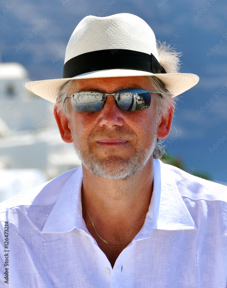 Santorini summer with panama hat, feather and sunglasses Santorini summer with panama hat, feather and sunglasses