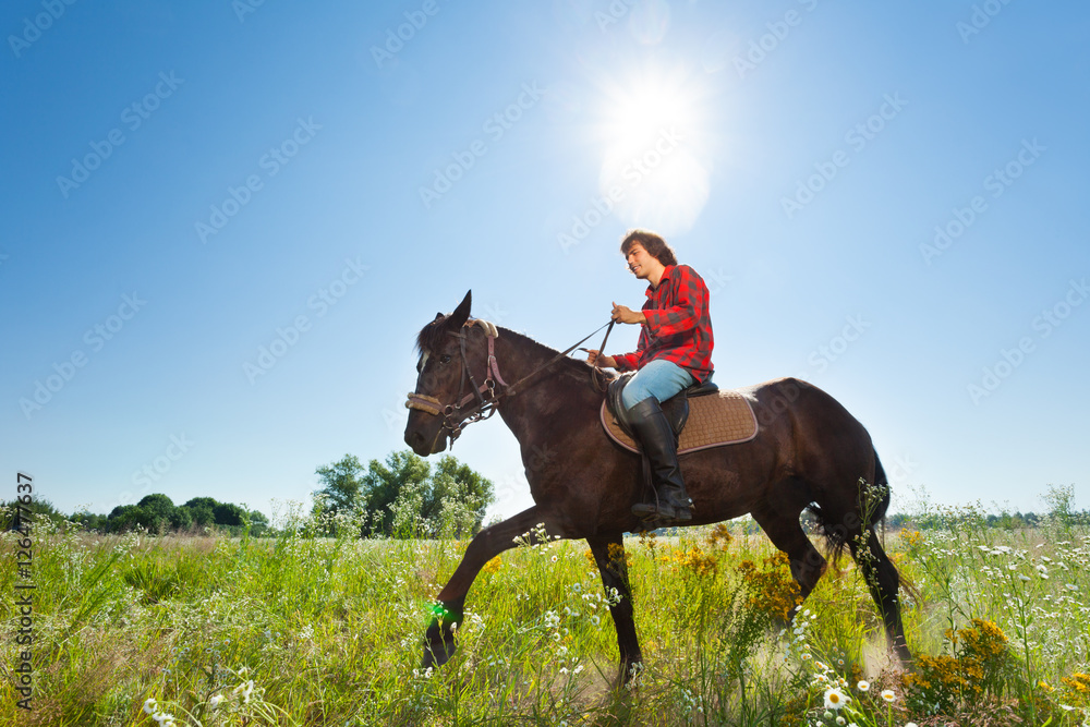 Young man horse ridding in the green outback Young man horse ridding in the green outback