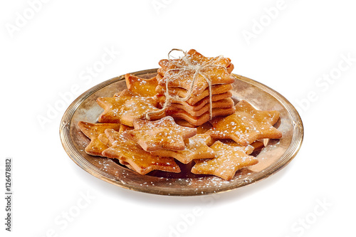Composition of star shaped ginger cookies on old metal dish over white background