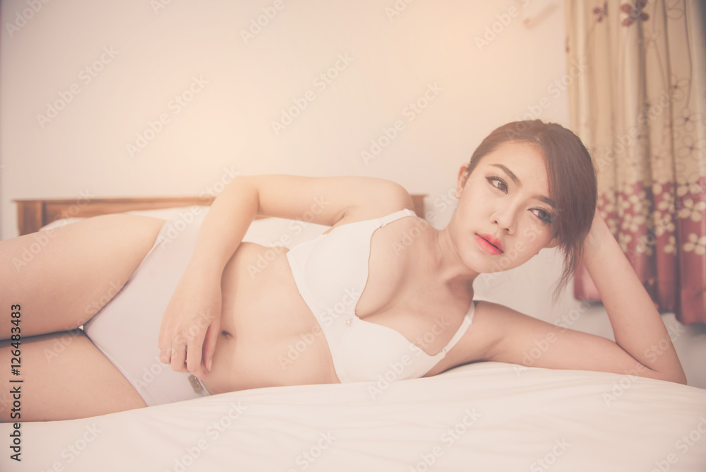 Obraz premium A sexy young woman lying on her bed in lingerie