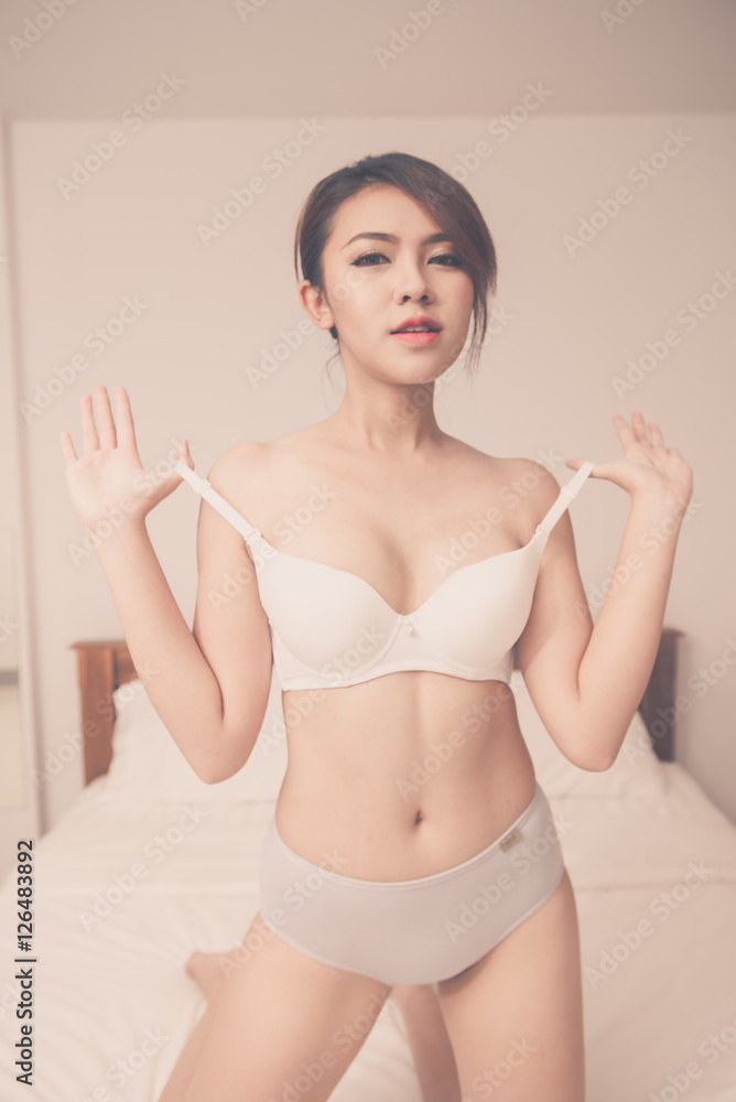 Obraz premium A sexy young woman lying on her bed in lingerie