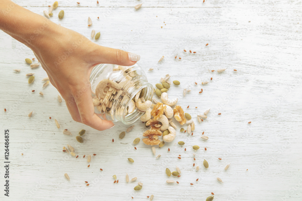 Seeds and nuts are spilling from the jar
