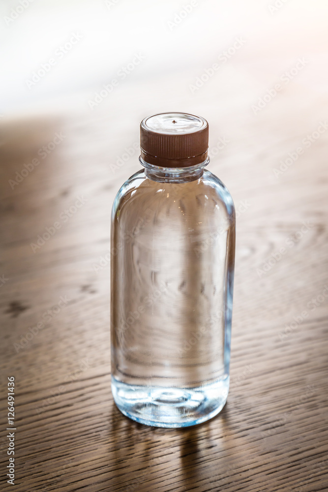 Plastic water bottle on wooden table texture