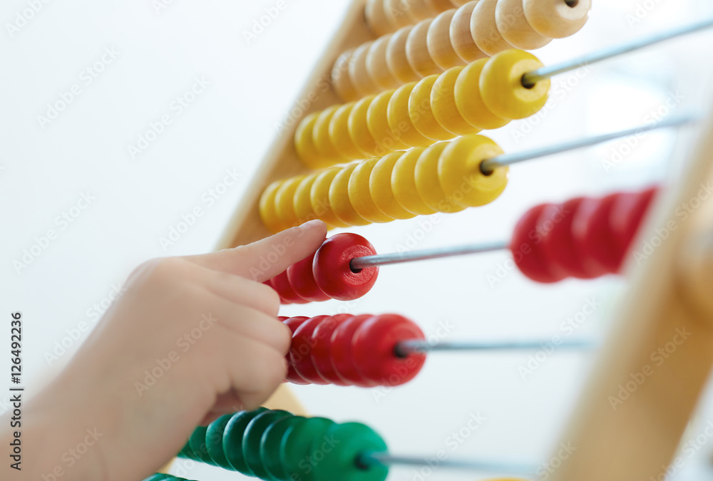 Little boy's hand playing with counter toy closeup. The concept of children's economic education. Little boy's hand playing with counter toy closeup. The concept of children's economic education.