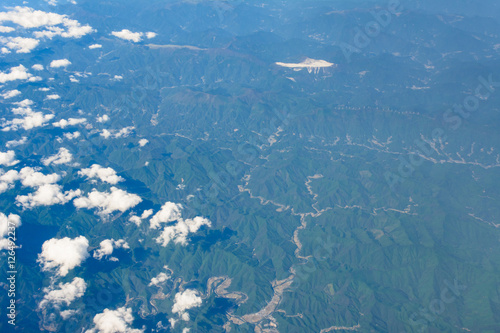 Картината върху платно Small clouds floating above misty aerial view of mountain range