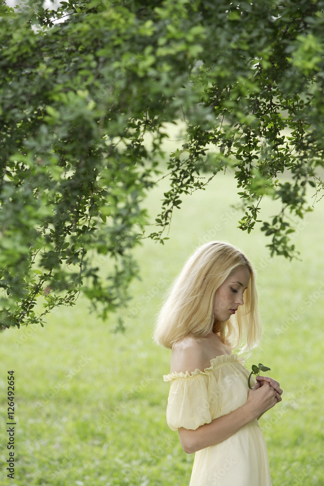 Young woman in yellow dress in green field Young woman in yellow dress in green field