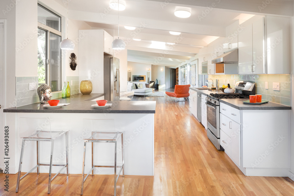 Open kitchen with bar chairs and with living room and tilted roo Open kitchen with bar chairs and with living room and tilted roo