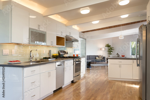 Amazing decorated white kitchen with living room.