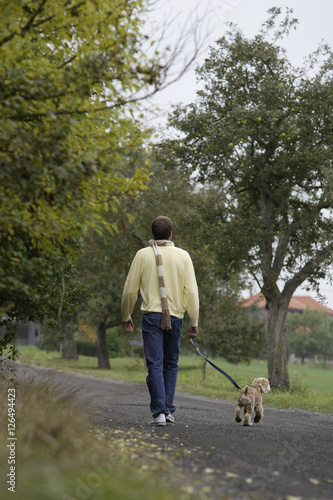 Young man walking dog